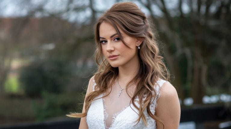 Woman in white dress outdoors, elegant and serene.
