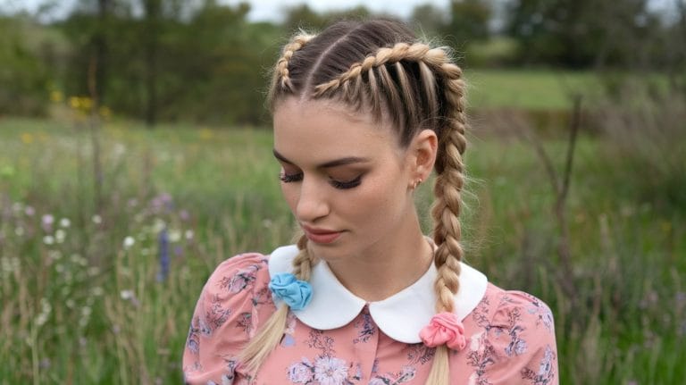 Woman with braids in floral dress outdoors.