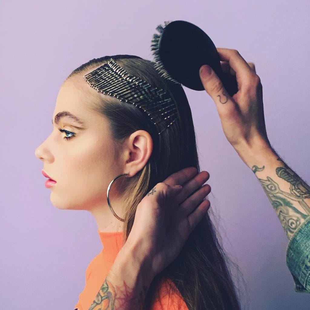 Stylist arranging model's hair with pins.