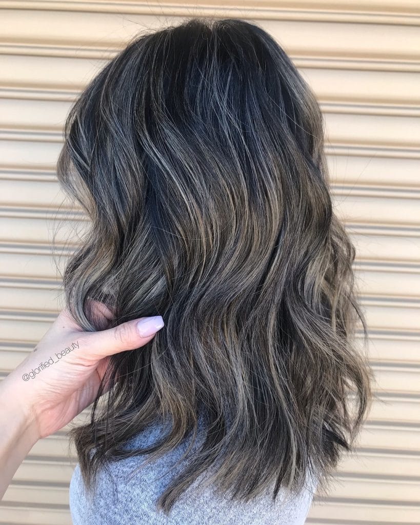 Wavy dark hair with subtle highlights