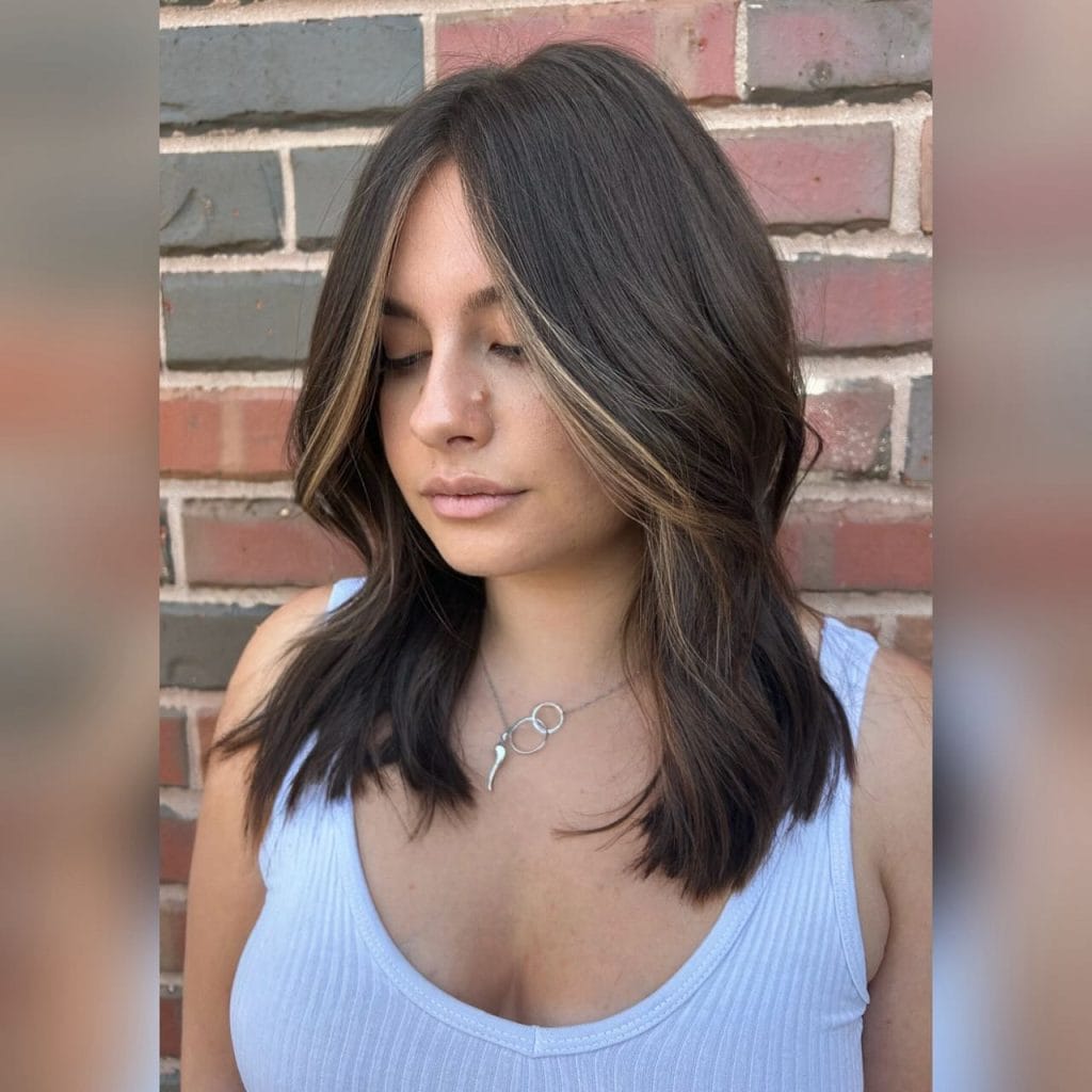 Woman with layered hairstyle and necklace.