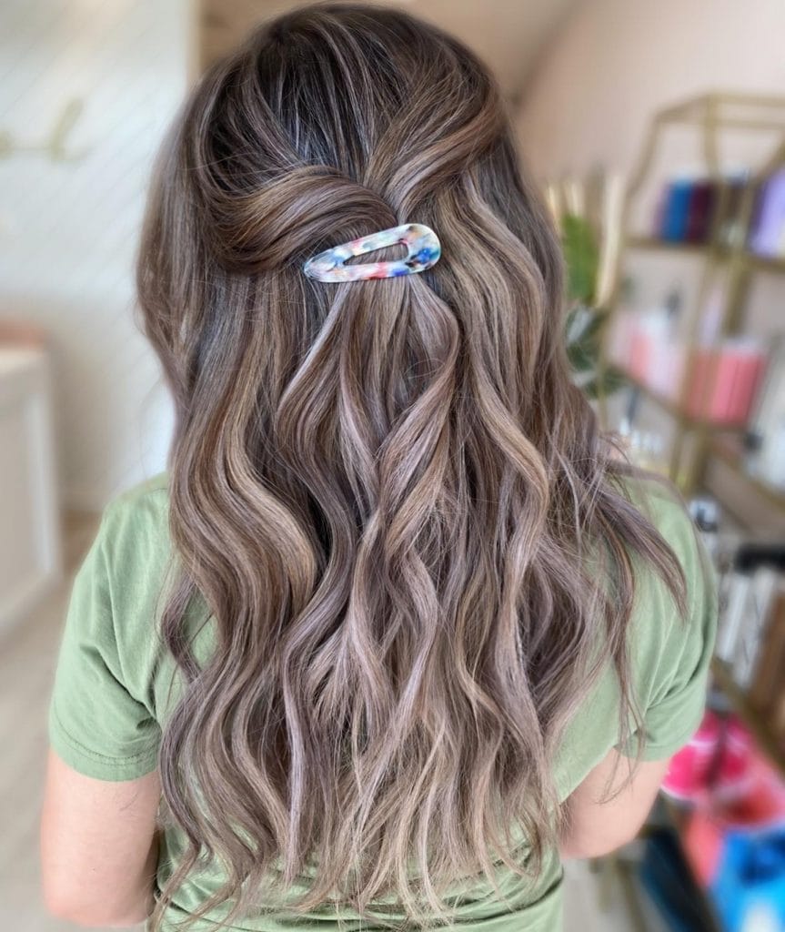 Woman with wavy hair and colorful hair clip.