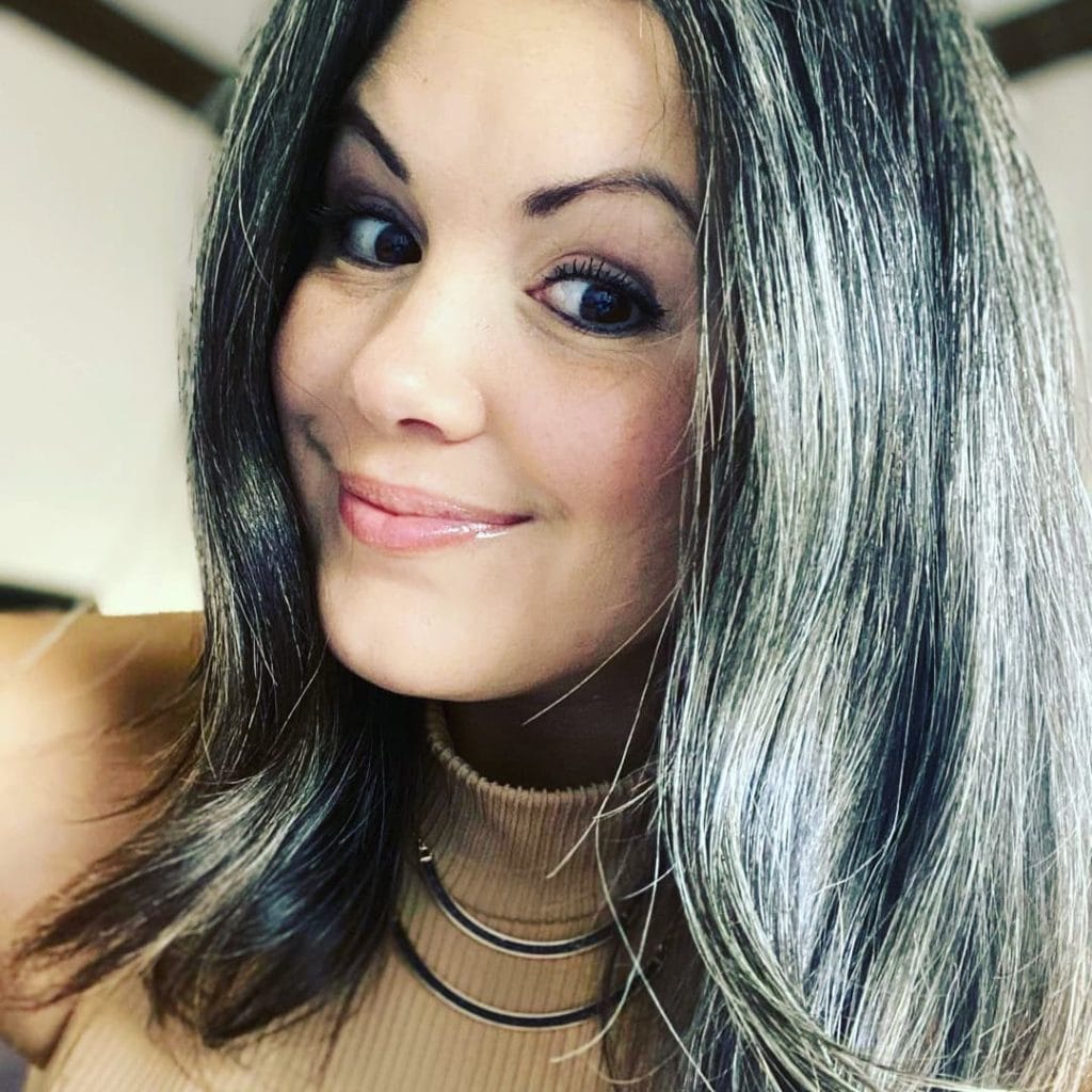 Smiling woman with gray streaked hair portrait.