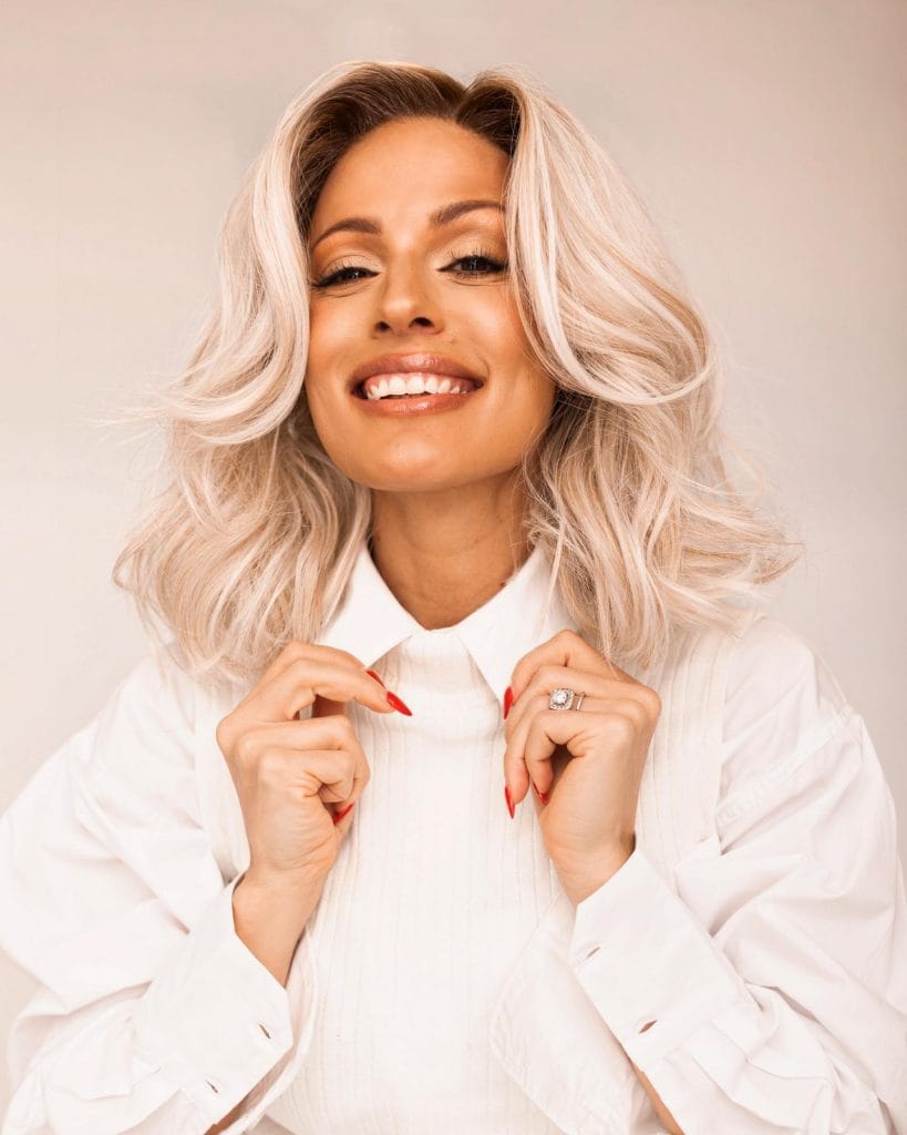 Smiling woman with blonde hair in white shirt
