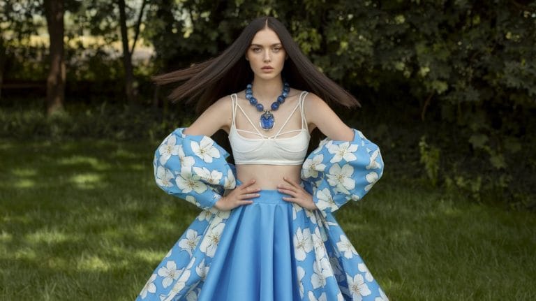 Woman in floral dress outdoors with necklace