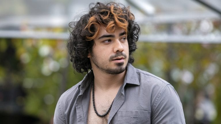 Person with curly hair wearing gray shirt