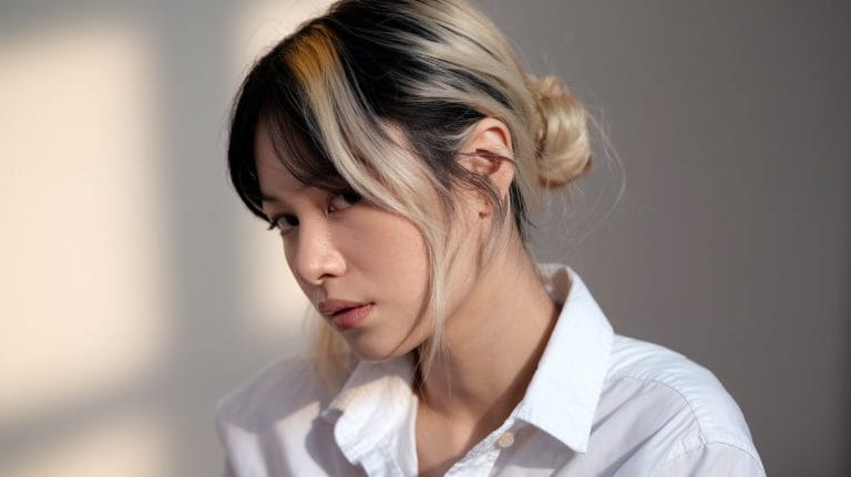 Portrait of a thoughtful person with dyed hair.