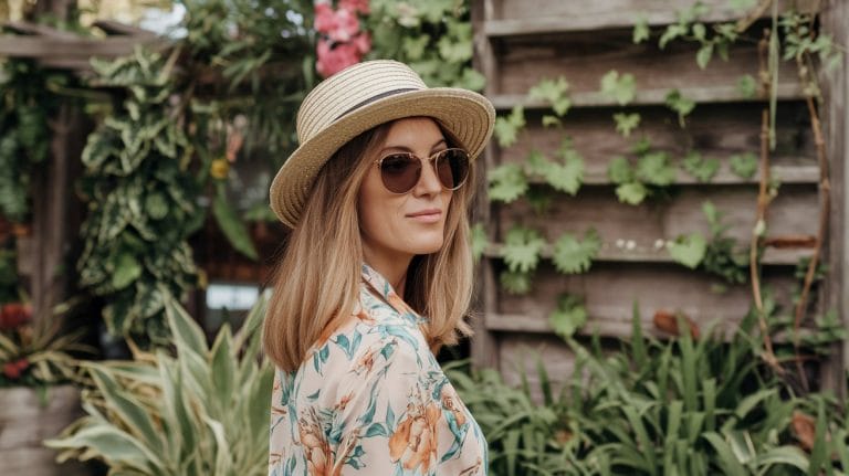 Woman with sunglasses in garden setting.