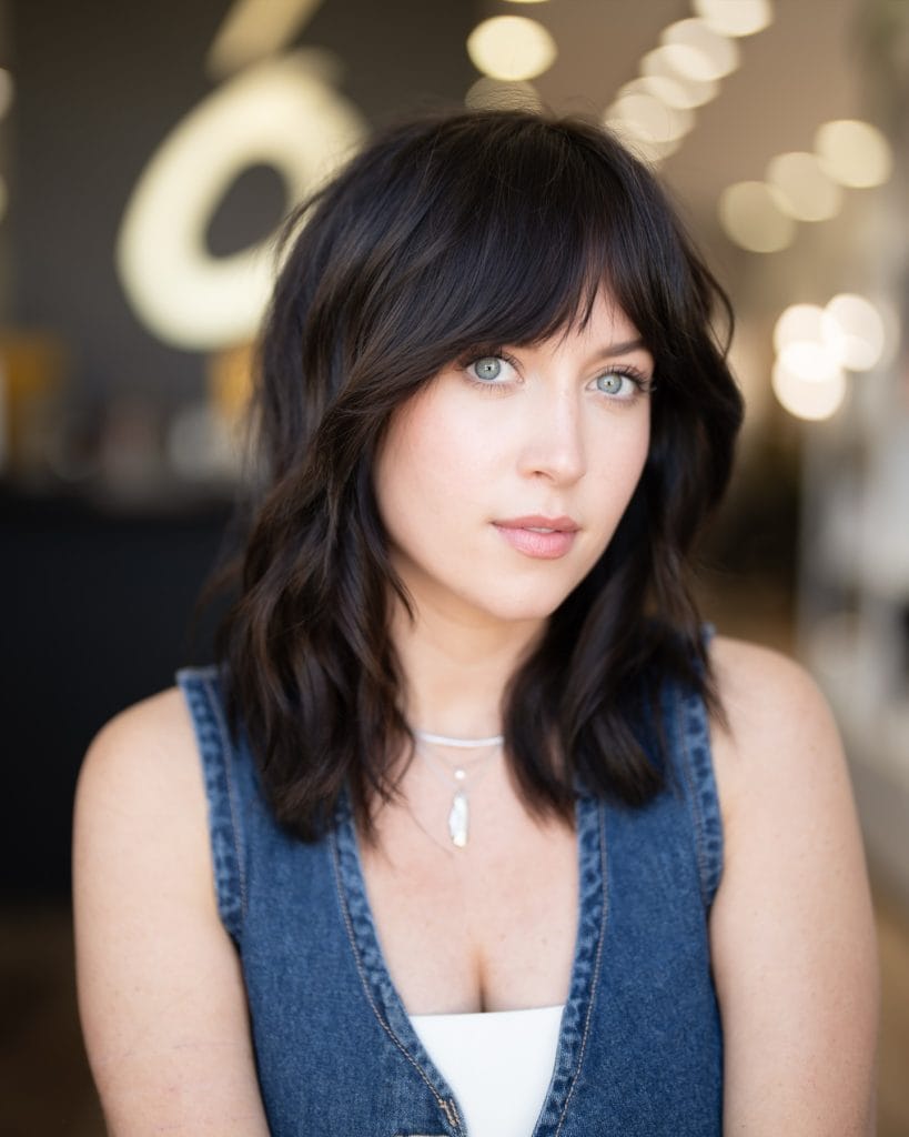Woman with dark hair in denim top.