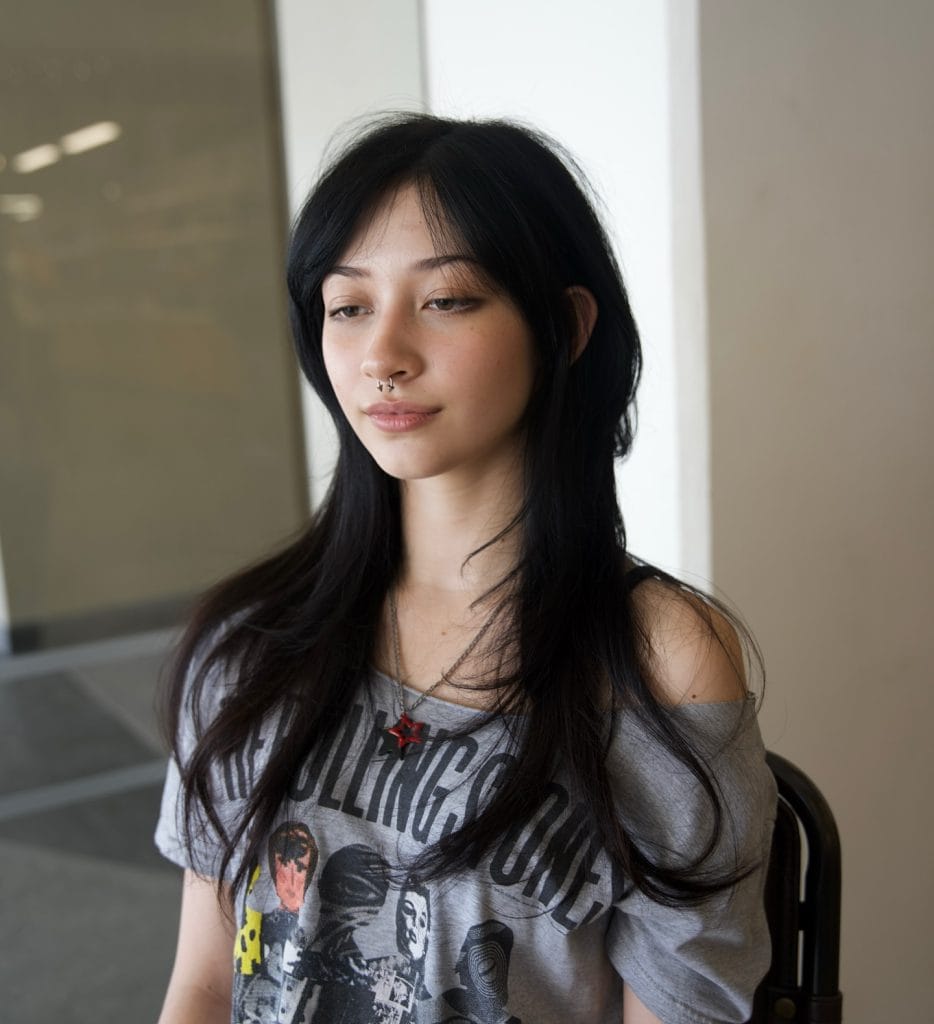 Person wearing Rolling Stones shirt indoors.