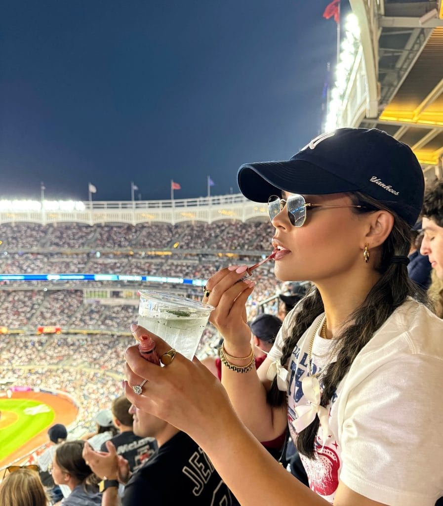 Woman enjoying a drink at baseball stadium