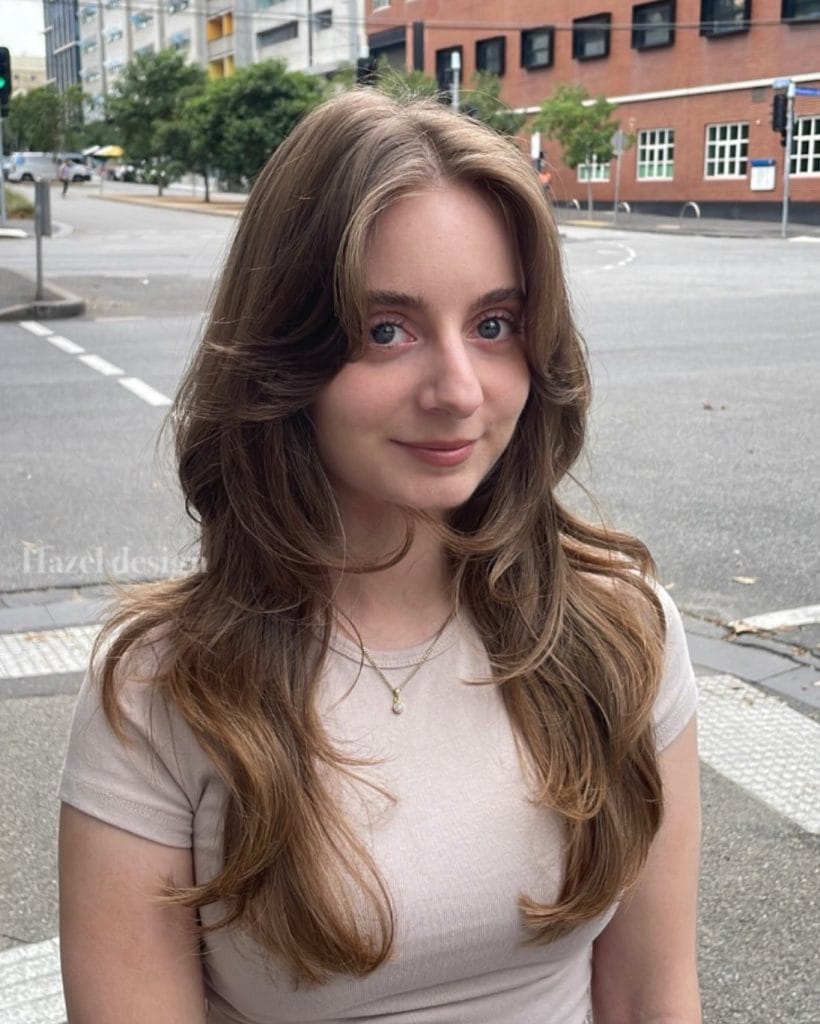 Woman smiling with city street background.
