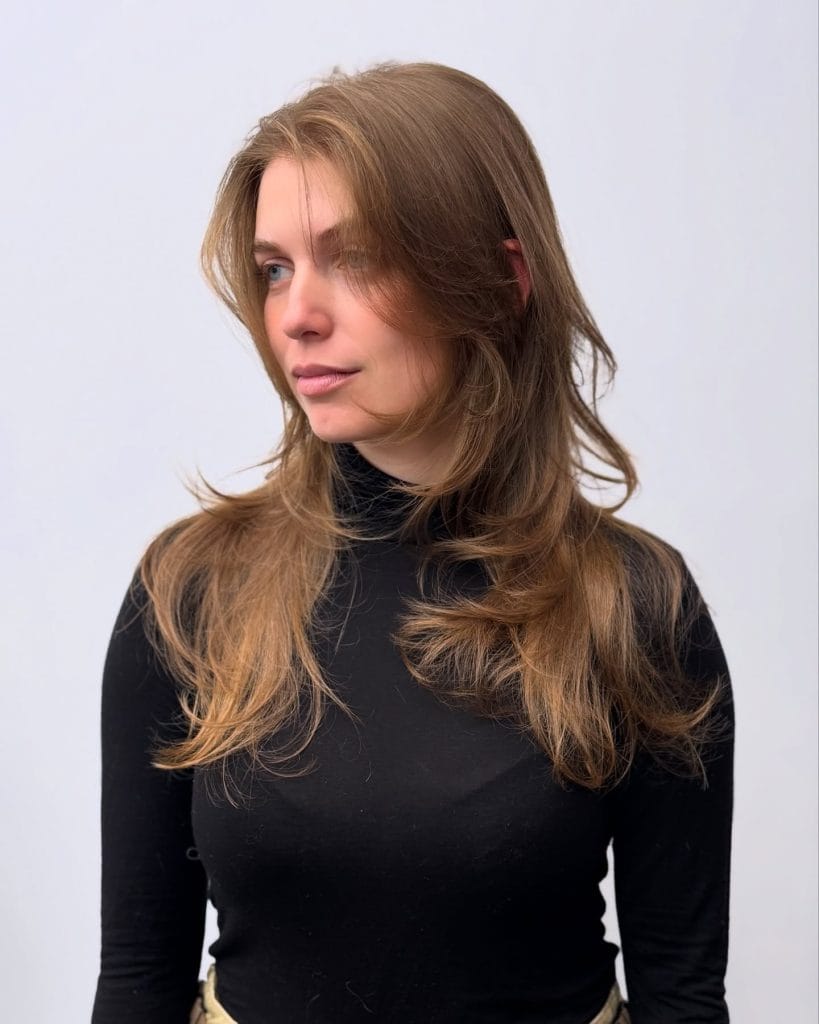 Person with long hair wearing a black turtleneck
