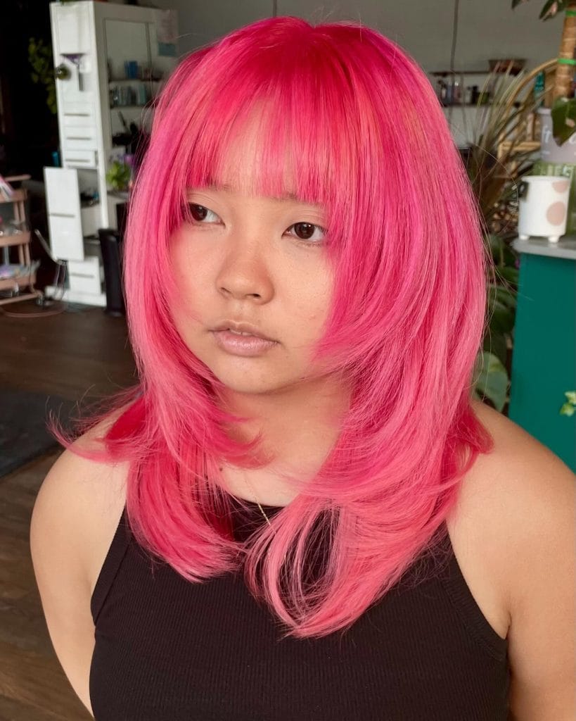 Person with bright pink layered hairstyle.