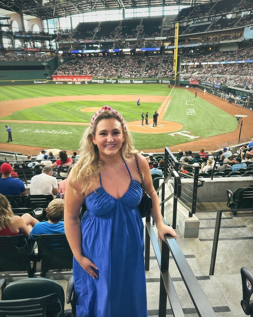 Woman smiling at baseball stadium entrance