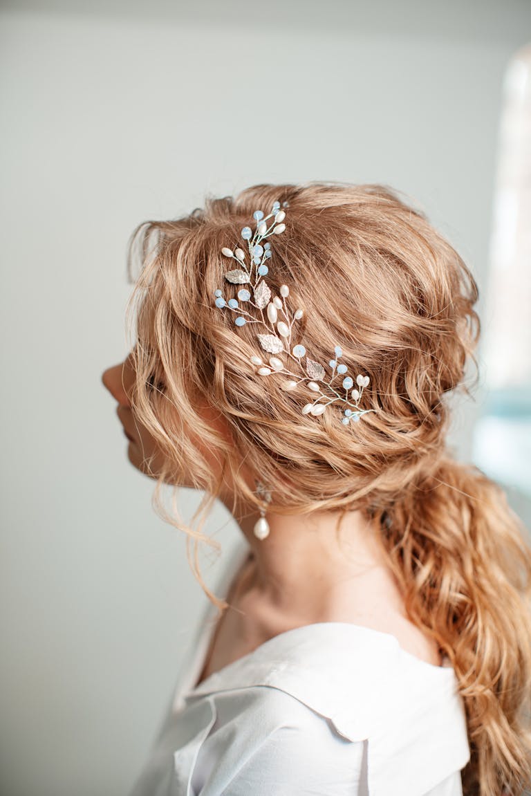 Close-up of a woman's blonde hair styled with a delicate bridal hair accessory.